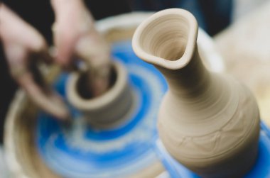 Çömlek atölyesindeki çömlekçi çarkında kil modellemesi üzerine sokak ustası sınıfı. Vazoya odaklan, vazoyu arka planda bulanıklaştırma işlemi