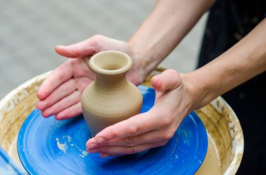 Çömlek atölyesinde çömlekçi çarkında kil modellemesi üzerine sokak ustası sınıfı.