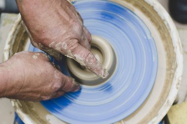 Çömlek atölyesinde çömlekçi çarkında kil modellemesi üzerine sokak ustası sınıfı.