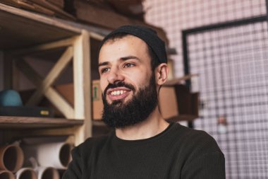 Erkek depo çalışanı depodaki raflardaki kutuları ya da belgeleri inceliyor.