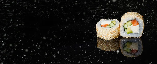 黒雪の背景に巻き寿司の本物の作品 クリスマスだよ — ストック写真