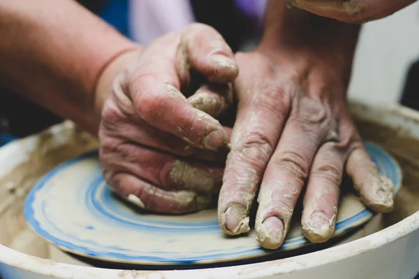 team work in a duet while studying an experienced master and student and providing clay forms. The process of changing the form from clay to the jug