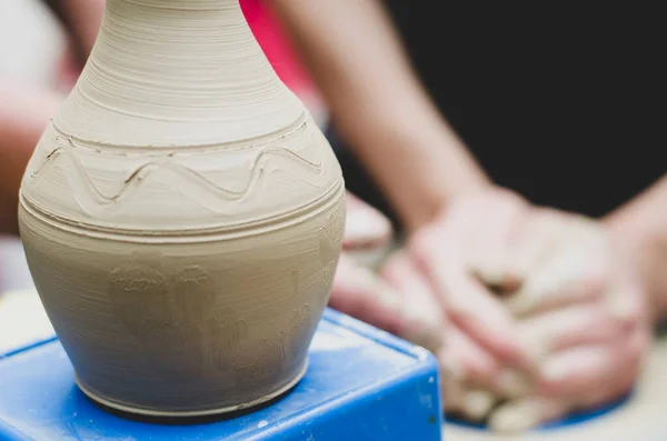 陶芸家の車輪の上の粘土のモデリングに関するストリートマスタークラス陶芸ワークショップで 花瓶に焦点を当て 花瓶を背景にぼかすプロセス — ストック写真