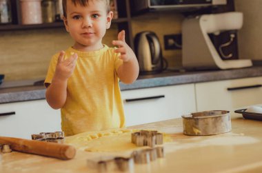 Çocuk portresi Mutfakta Pişirmeye Başla. Gündelik giysiler giyen küçük şirin çocuklar. Ellerinde yuvarlak raptiye yapmaya başla. Gıda Hazırlama Konsepti