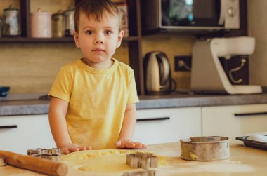 Çocuk portresi Mutfakta Pişirmeye Başla. Gündelik giysiler giyen küçük şirin çocuklar. Ellerinde yuvarlak raptiye yapmaya başla. Gıda Hazırlama Konsepti