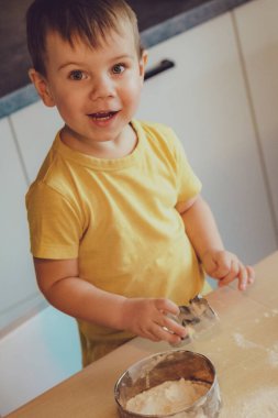 Çocuk portresi Mutfakta Pişirmeye Başla. Gündelik giysiler giyen küçük şirin çocuklar. Ellerinde yuvarlak raptiye yapmaya başla. Gıda Hazırlama Konsepti