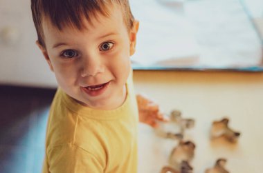 Evde mutfakta yemek pişiren sevimli çocuk. Mutfakta aile eğlencesi kavramı, çocuk çeşitli yemekler hazırlıyor: makarna, kurabiye, ekmek, zencefilli ekmek..