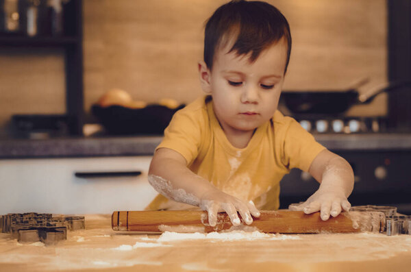 Portrait of child Boy Start Cooking at Kitchen. Young Cute Children Wearing Casual Clothes. Start Making Cake Holding Rolling Pins in Hands. Food Preparation Concept