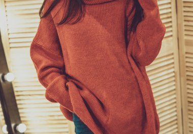 Güzel model esmer kız şık kıyafetler içinde kırmızı renkli, giyim mağazasında poz veren, yeni moda kıyafetler giyen. Bir giyim mağazasının afişi. Galeriler, moda mağazaları, kapak hikayeleri, dahili stüdyolar için.