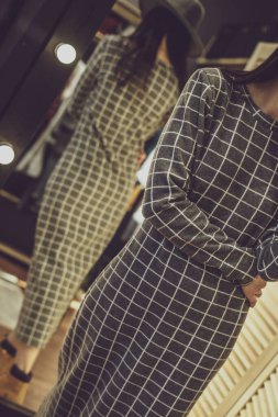 Şık kıyafetler içinde şık, güzel model esmer kız, giyim mağazasında poz veriyor, yeni bir moda. Bir giyim mağazasının afişi. Galeriler, moda mağazaları, kapak hikayeleri, dahili stüdyolar için.