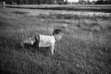 Mutlu genç aile dışarıda yeşil doğada birlikte vakit geçiriyor.
