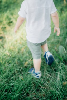 Mutlu genç aile dışarıda yeşil doğada birlikte vakit geçiriyor.