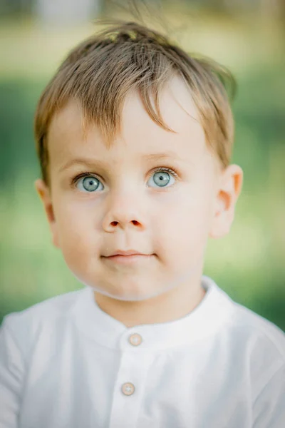 肖像男婴穿着时髦的白色衬衫和深绿色裤子 带着甜美的微笑 自然绿色背景 — 图库照片