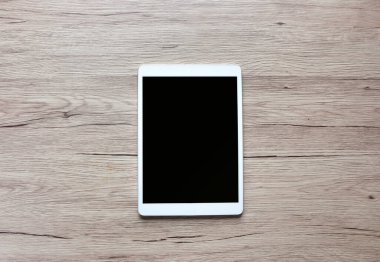 Tablet Kopyalama alanı olan ahşap bir masaya koy.