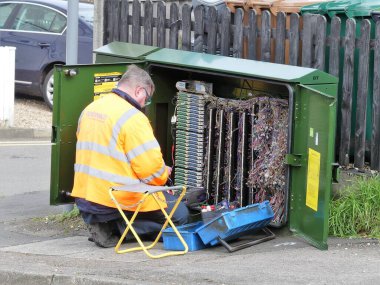 BT Openreach mühendisi kabinede çalışıyor. Openreach, telekomünikasyon şirketi BT plc 'nin işlevsel bir bölümüdür..