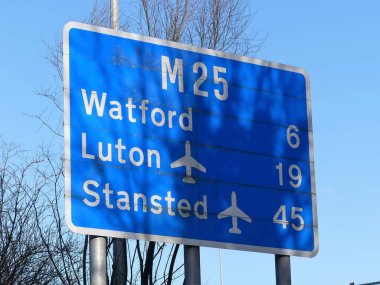 Chorleywood, Hertfordshire 'daki M25 otoyolu tabelası Watford, Luton Havaalanı ve Stanstead Havaalanı' na olan mesafeyi gösteriyor.