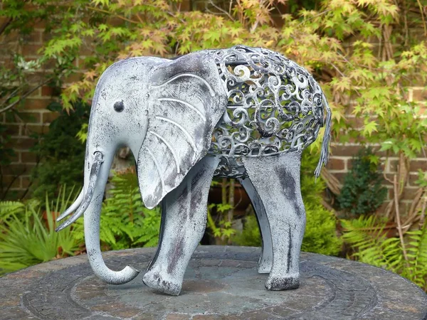 Metal sculpture of African elephant on stone garden table