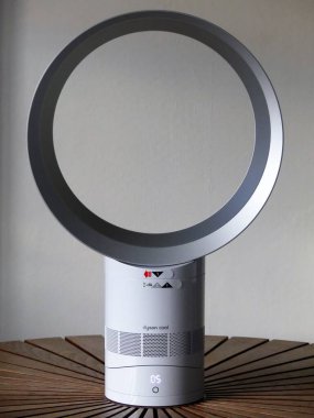 Dyson Cool AM06 beyaz masa vantilatörü yuvarlak ahşap masaya yerleştirilmiş