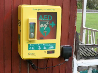 Tahta duvarın dışına monte edilmiş otomatik dış defibrilatör (AED) çelik ünitesi