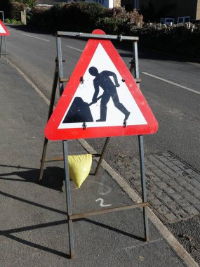 Yol kenarındaki metal çerçeve üzerinde üçgen yol çalışması işareti