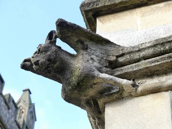 Gargoyle on top of the tower of St Mary\'s Church, Old Amersham, Buckinghamshire, UK. A gargoyle is a projecting stone waterspout which was often used in Gothic architecture.