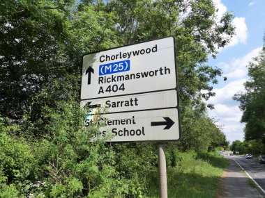 Hertfordshire 'daki A404 yolunda Chorleywood, M25 otoyolu, Rickmansworth, Sarratt ve St. Clement Danes Okulu' na giden yol tabelaları.