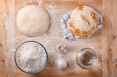 Pasta tahtasında ekmek ve temel malzemeler, üst görünüm.