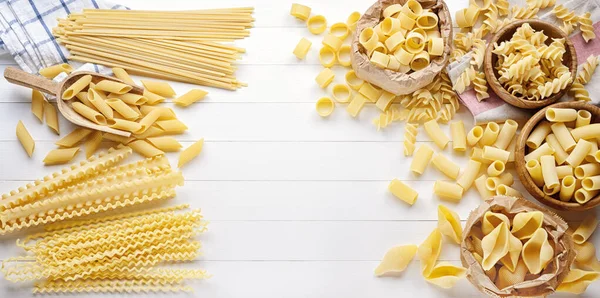 Çeşitli ham makarna: kalemler, kabuklar, rigatoni, fusilli, linguine, ve mürekkep balığı, üst görünüm, boşluk kopyala. 