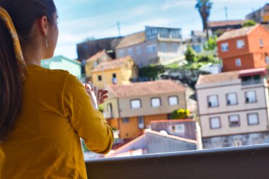 Koronavirüs salgını sırasında tüm sağlık çalışanlarına şükranlarını sunan genç bir kadın ellerini balkonda çırpıyor.