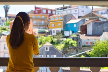 Koronavirüs salgını sırasında tüm sağlık çalışanlarına şükranlarını sunan genç bir kadın ellerini balkonda çırpıyor.