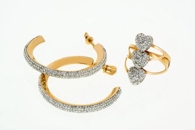 Taşlı beyaz elmaslı küpeler ve yüzükler. Beyaz arka planda kostüm mücevherleri. İzole edilmiş.