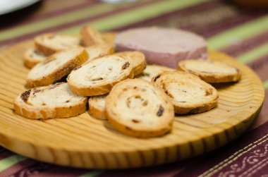 Kuru üzümlü börek. Bir parça organik börek ve kuru üzümlü çörekle tahta bir tahta görebilirsiniz..