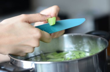 Yeşil fasulye pişiren fotoğraf koleksiyonu. İçinde bıçakla fasulye temizleyen bir kadın var..