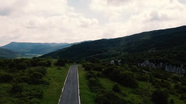 Images aériennes de la route de montagne. Avec un fond montagneux et entouré d'arbres, dans la vidéo, vous pouvez voir une petite route .