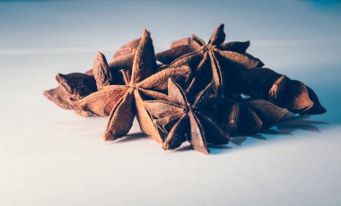 Beyaz arka planda anason ve tarçın birlikte