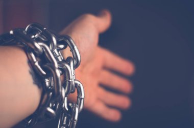 Erkeğin elindeki metal zincir bulanık arkaplanlı.