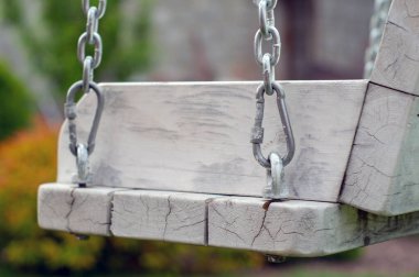 Bahçede yeşilliğin arka planında zincirli ahşap salıncak