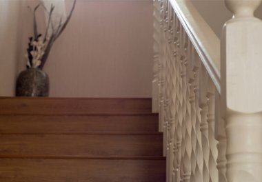 Beyaz korkuluklar ve balyalarla ikinci kata çıkan merdiven.