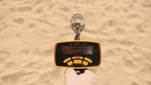 Persona escaneando arena con detector de metales en la playa. Punto de vista fotografiado — Foto de Stock