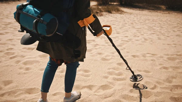 Mujer irreconocible con detector de metales en busca de artefactos caminando en la playa de arena en un día soleado — Foto de Stock