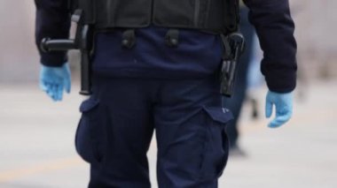 Varşova, Polonya 04.15.2020 - Girişimcilerin protestosu, önlem olarak eldiven takan polis memurunun arka planı. Sokağa çıkma yasağının ortasında protesto, koronavirüs tecridi