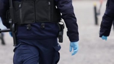 Varşova, Polonya 04.15.2020 - Girişimcilerin protestosu, önlem olarak eldiven takan polis memurunun arka planı. Sokağa çıkma yasağının ortasında protesto, koronavirüs tecridi