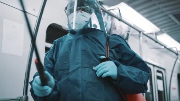 Pulitore con tuta protettiva, schermo facciale e maschera medica disinfezione treno — Video Stock