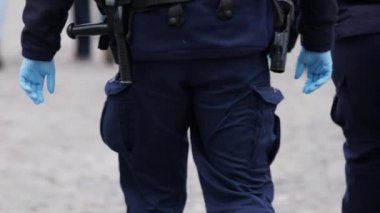 Varşova, Polonya 04.15.2020 - Girişimcilerin protestosu, önlem olarak eldiven takan polis memurunun arka planı. Sokağa çıkma yasağının ortasında protesto, koronavirüs tecridi