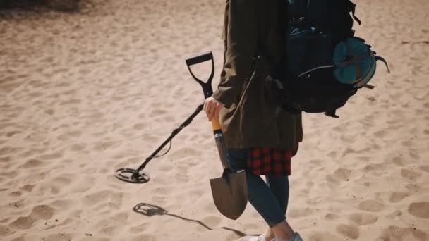 Explorer με το σακίδιο πλάτης, το παπούτσι και τον μεταλλικό ανιχνευτή περπατώντας στην αμμώδη παραλία. ψάχνοντας για το θησαυρό — Αρχείο Βίντεο
