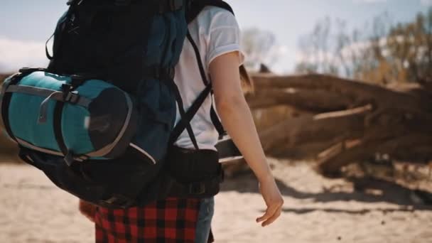 De cerca, mujer mochilera, viajera con la cámara caminando por la playa de arena. Concepto de aventura y exploración — Vídeo de stock