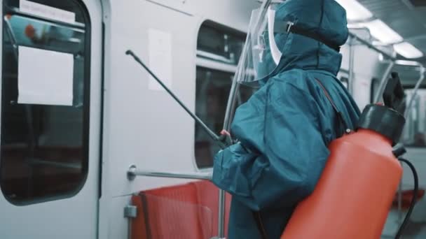 Dezinfekce veřejné dopravy. Muž s ochranným skafandrem obličejovým štítem a lékařskou maskou — Stock video