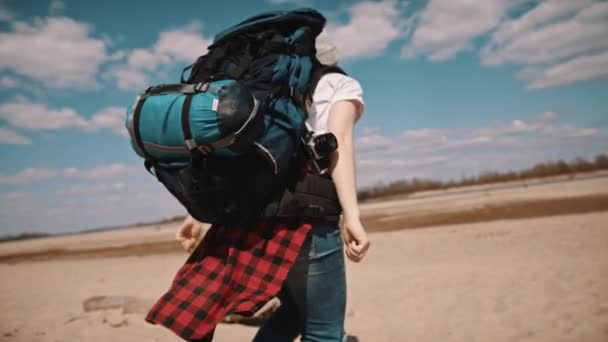 Ung kvinna backpacker kör längs sandstranden. Inget ansikte, långsam rörelse — Stockvideo