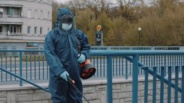 Hombre africano con traje de protección NBC, máscara, gafas de protección facial, desinfecta escaleras — Vídeos de Stock