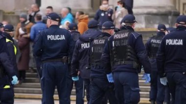 Varşova, Polonya 04.15.2020 - Girişimcilerin protestosu, sokağa çıkma yasağı saatlerinde Varşova 'da yüzleri maskeli birçok polis memuru